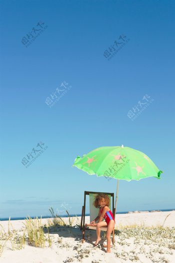 在沙滩上晒太阳的小女孩图片