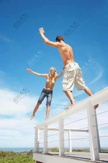 在别墅阳台栏杆上玩耍的情侣图片
