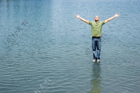 双手展开站立在水面的男人图片