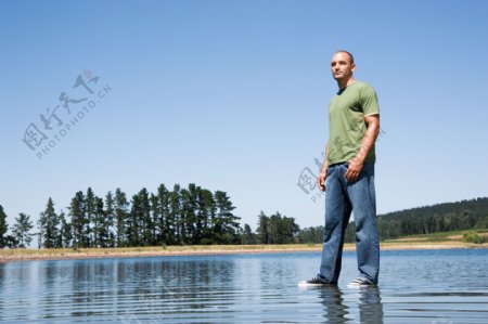 站立在水面的外国男人图片