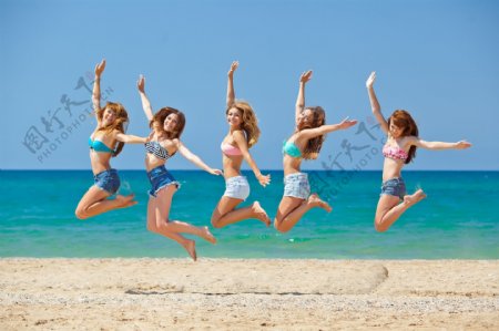 海滩跳跃的性感美女图片