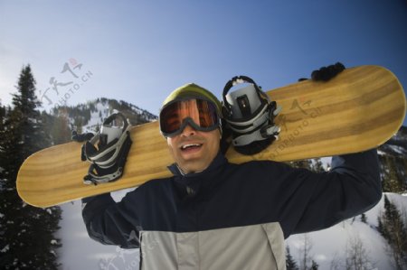 肩扛滑雪板的男性图片