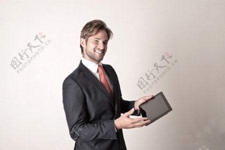 展示平板电脑的商务男人图片