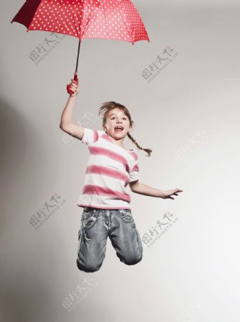 拿着雨伞跳跃的外国小女孩图片