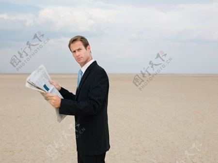 站着干旱地里看报纸的男人图片