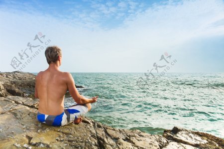 海边练瑜伽的男士图片