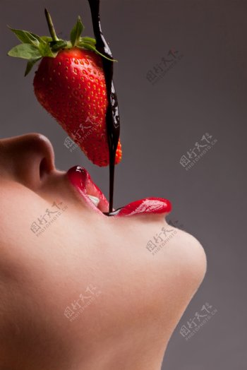吃草莓巧克力的女孩特写图片