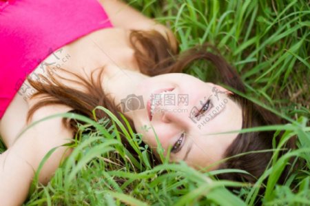 躺在草地面带微笑的女孩