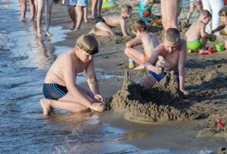男孩在沙滩玩泥巴