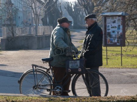 推着自行车交流的老人