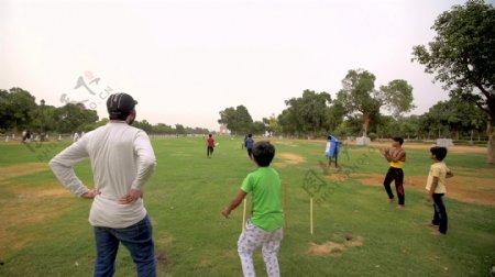 在公园里玩板球的印度孩子