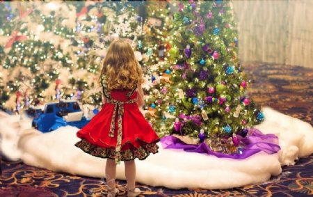 站在圣诞树下兴奋的小女孩